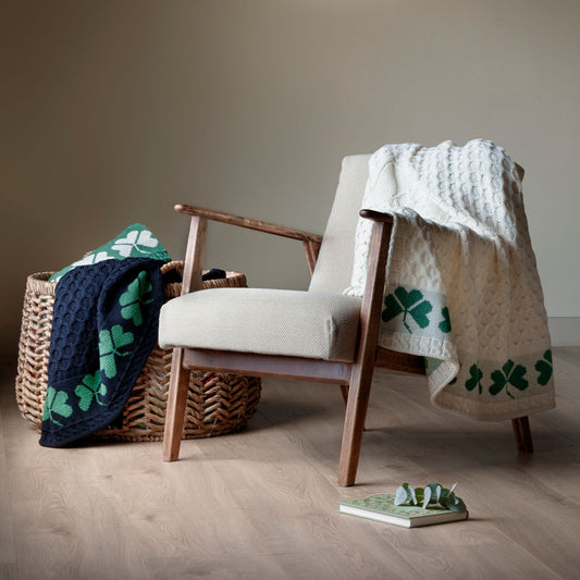 Chair with a blanket draped over it in a room with a painting on the wall.