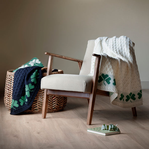 Chair with a blanket draped over it in a room with a painting on the wall.