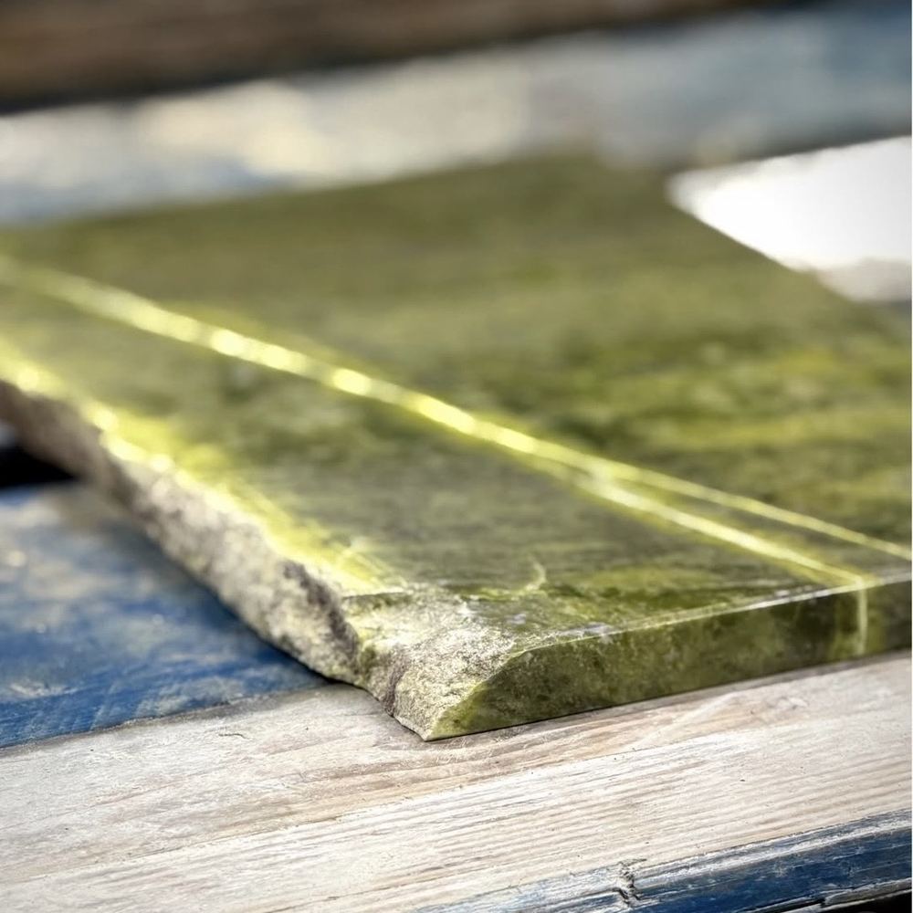 Close-up of a polished slab of genuine green Connemara marble showing its natural veining